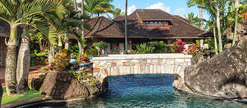 The backyard and pool with a built in waterfall for the Enchanting Meadow house for vacation rental