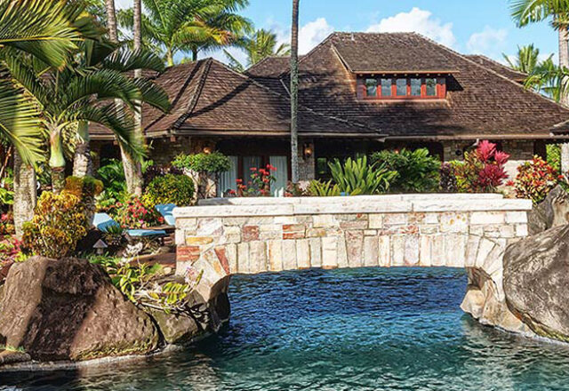 The backyard and pool with a built in waterfall for the Enchanting Meadow house for vacation rental