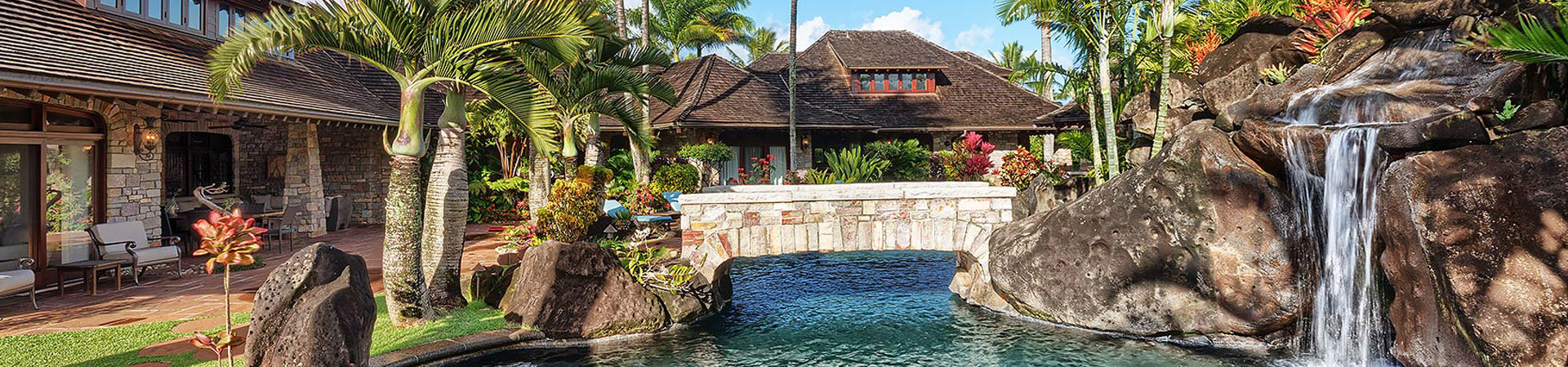 The backyard and pool with a built in waterfall for the Enchanting Meadow house for vacation rental
